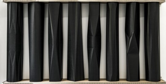 Installation\r<br>24 Unique objects in a shelf with 3 compartments\r\nPressboard, metal\r\nInstallation: 313 x 211 x 24 cm \r\n\r\nPhoto: Ute Schendel, courtesy Galerie Gilla Loercher